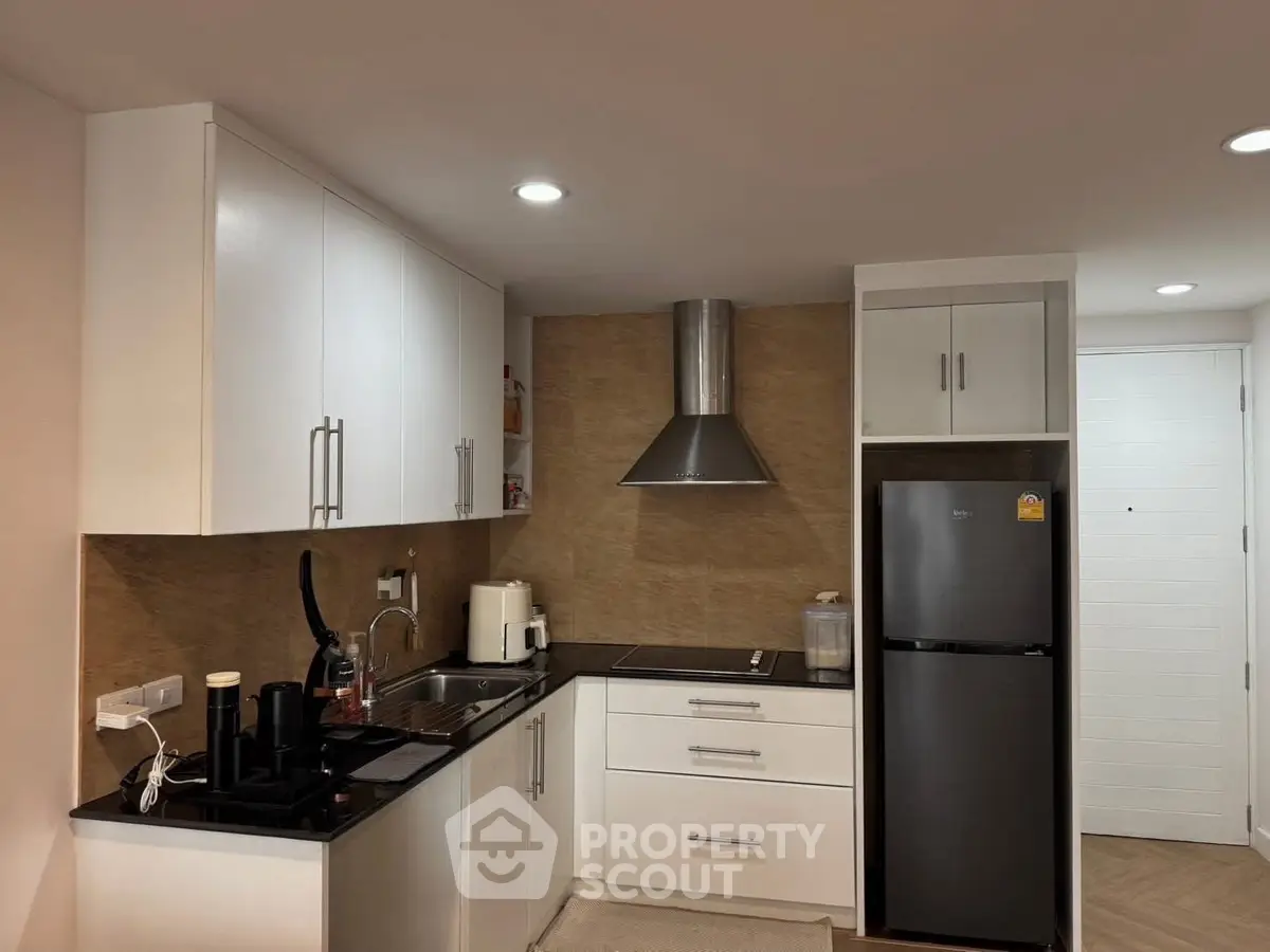 Modern kitchen with sleek white cabinets and stainless steel appliances