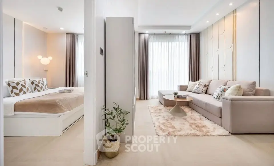 Modern open-plan living room and bedroom with stylish decor and natural light.