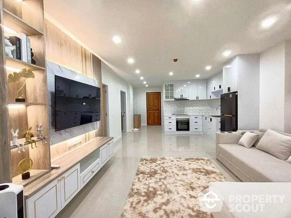 Spacious modern living room with open kitchen, sleek design, and cozy ambiance.