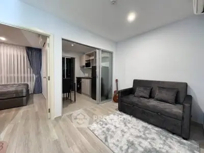 Modern apartment interior with cozy living room and open kitchen layout, featuring sleek furniture and stylish decor.