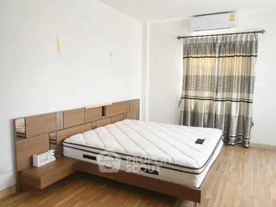 Spacious bedroom with modern wooden bed and elegant curtains