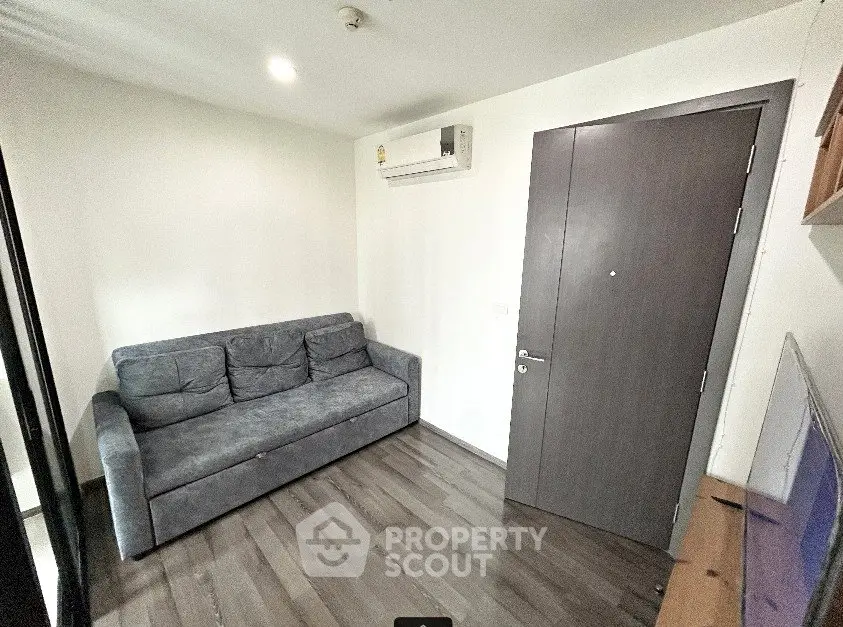Cozy living room with gray sofa and modern air conditioning unit, perfect for relaxation.