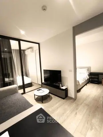 Modern living room with sleek design and open view into bedroom, featuring stylish furniture and neutral tones.