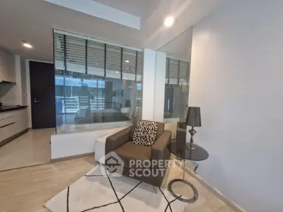 Modern living room with glass wall, cozy armchair, and stylish decor