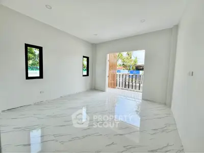 Spacious empty room with glossy marble flooring and large windows offering natural light.
