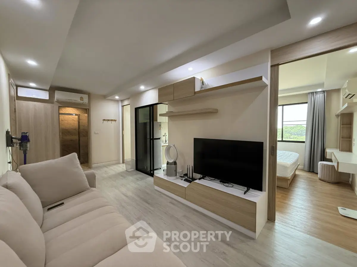 Modern living room with sleek design and open layout, featuring cozy sofa and large TV unit.