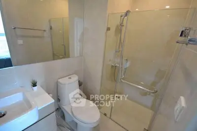 Modern bathroom with glass shower and sleek fixtures in a contemporary home.