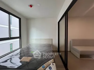 Modern bedroom with large windows and minimalistic design in a contemporary apartment.