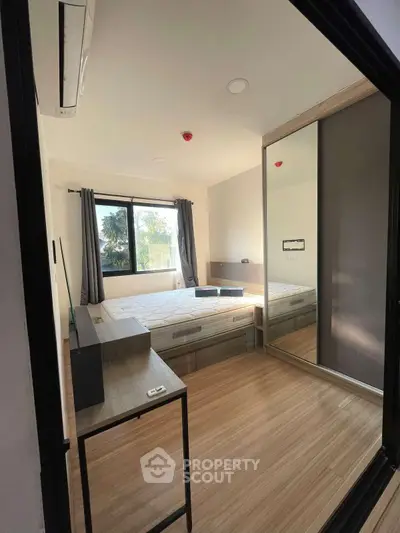 Modern bedroom with large window and mirrored wardrobe
