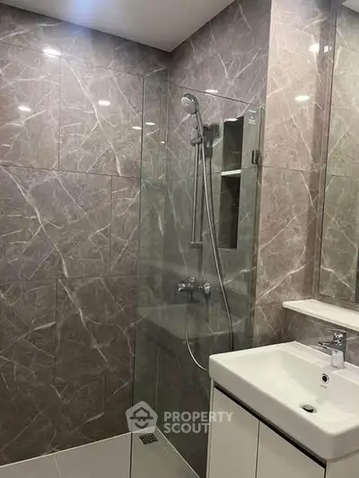 Modern bathroom with sleek glass shower and elegant marble tiles