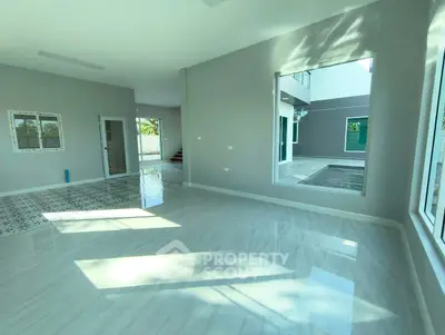 Spacious modern living room with large windows and glossy floors