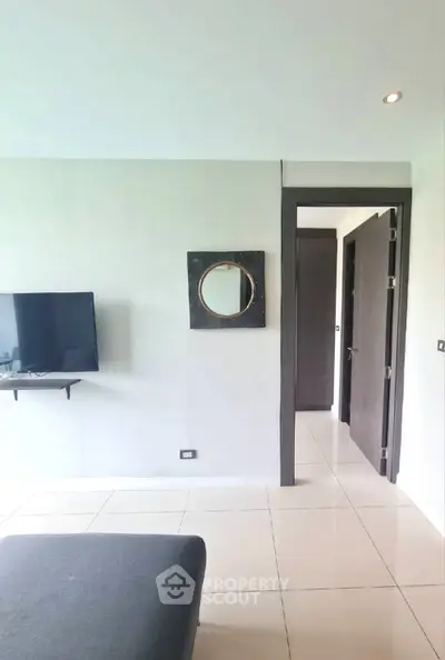 Modern living room with wall-mounted TV and stylish decor in a contemporary apartment.