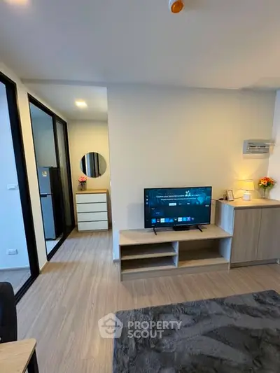 Modern living room with sleek TV setup and stylish decor in a cozy apartment.