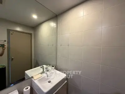 Modern bathroom with sleek sink and large mirror in a contemporary home.