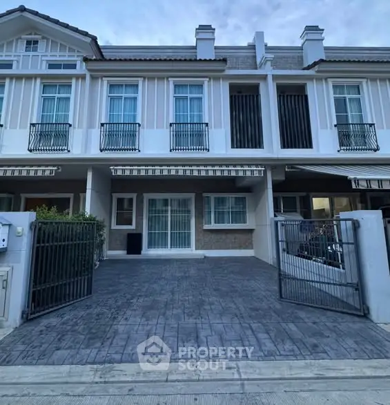 Modern townhouse exterior with gated driveway and stylish facade