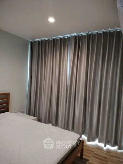 Cozy bedroom with modern curtains and wooden bed frame, perfect for relaxation.
