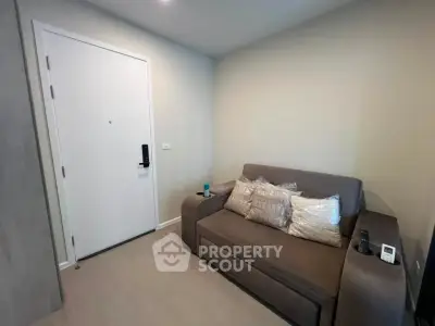 Cozy living room with modern sofa and secure door, perfect for urban living.