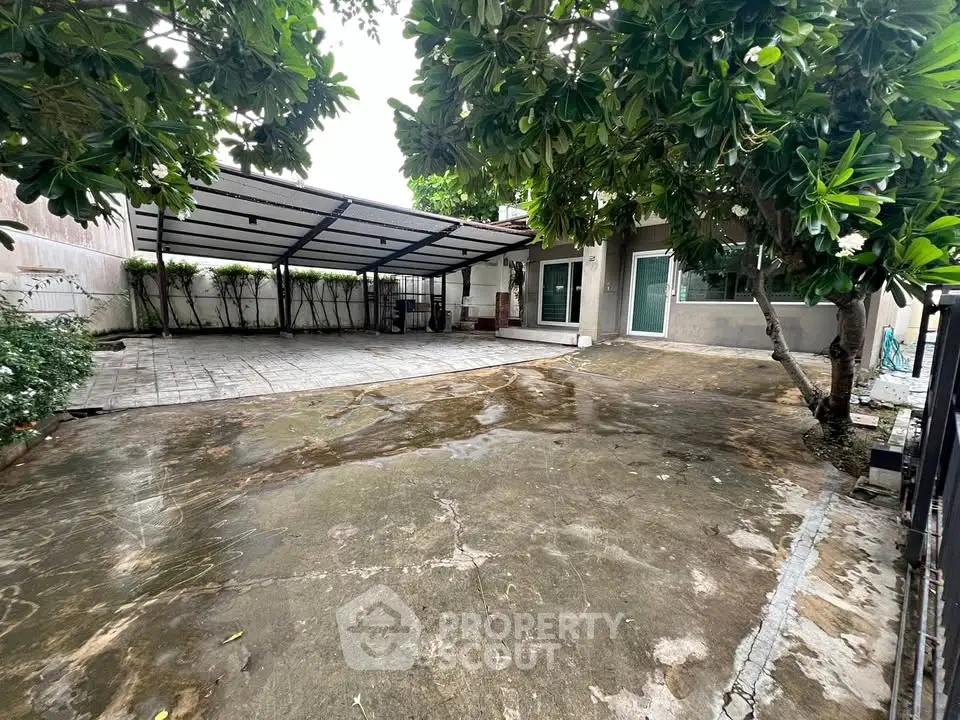 Spacious outdoor area with covered parking and lush greenery