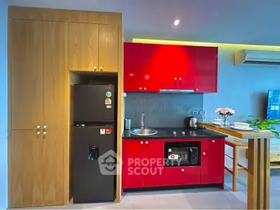 Modern kitchen with vibrant red cabinets and sleek appliances in open layout