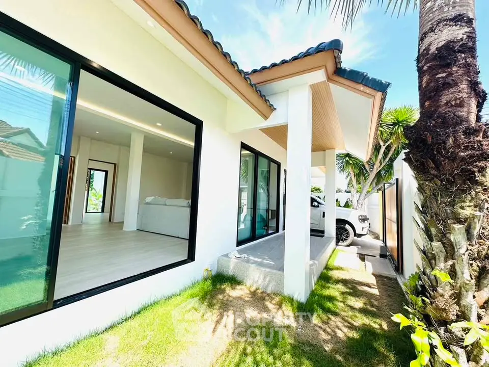 Modern single-story home with large glass doors and lush garden