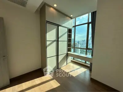 Bright room with large windows offering stunning city views and built-in storage.