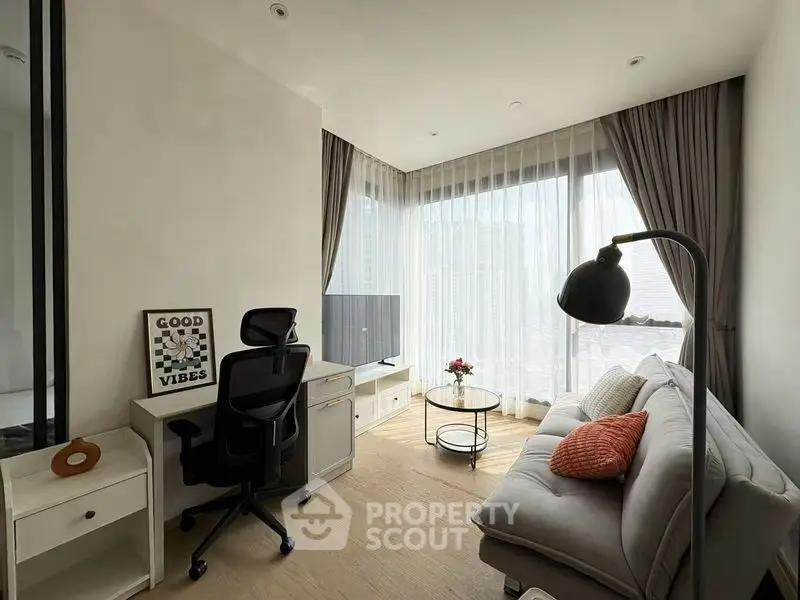 Modern living room with cozy sofa, desk, and large windows for natural light.