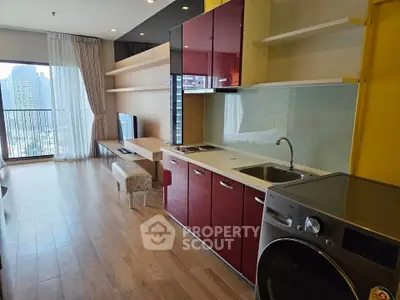 Modern open-layout living room with kitchen, featuring sleek cabinetry and city view balcony.