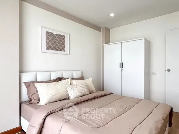Modern bedroom with stylish decor and ample storage in a cozy apartment.