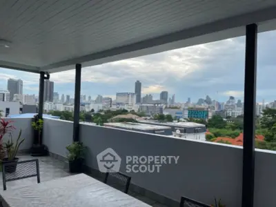 Stunning cityscape view from a spacious balcony with modern seating, perfect for relaxation and entertainment.