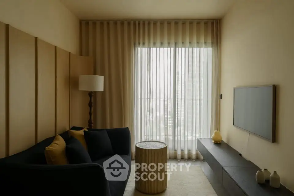 Modern living room with stylish decor and large window offering natural light.