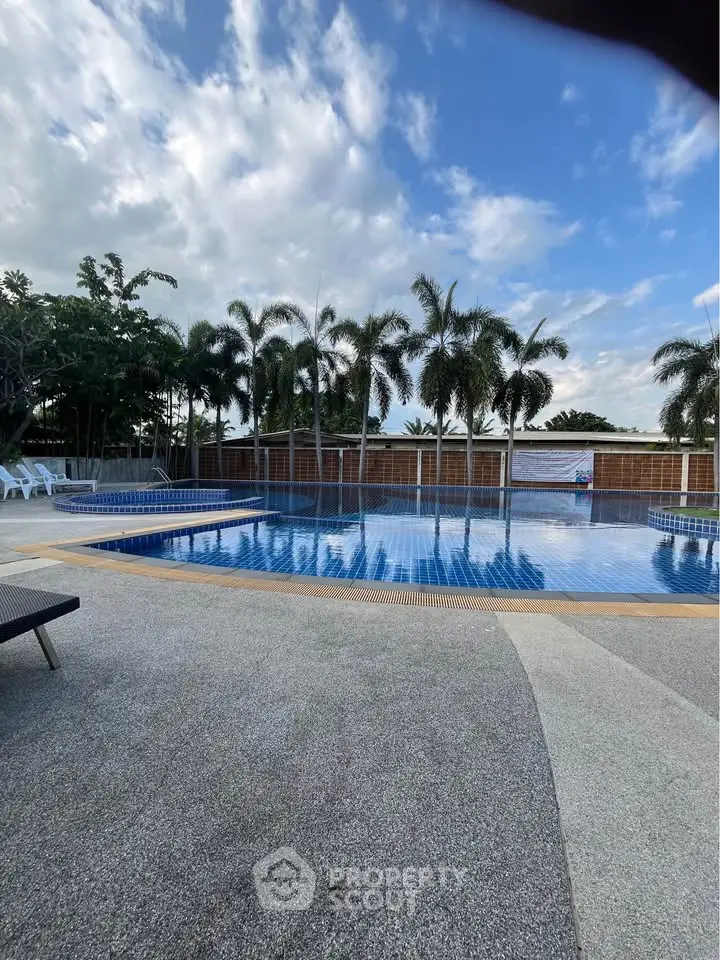 Luxurious outdoor pool area with palm trees and serene ambiance, perfect for relaxation and leisure.