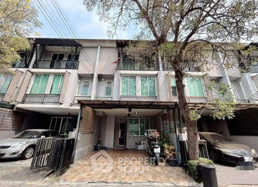 Modern townhouse with carport and balcony in a serene neighborhood setting.