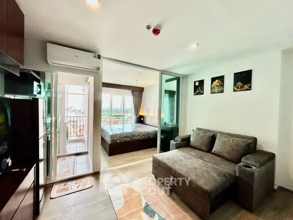 Modern living room with cozy sofa and view into stylish bedroom