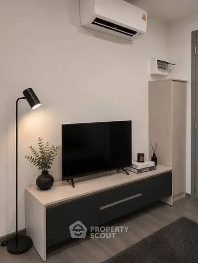 Modern living room with sleek TV stand, air conditioning, and stylish decor.