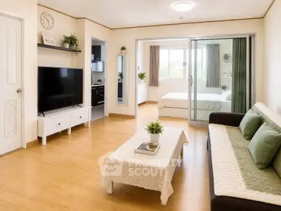 Spacious living room with modern decor and view into cozy bedroom