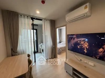 Modern living room with air conditioning and TV, adjacent to a cozy bedroom.