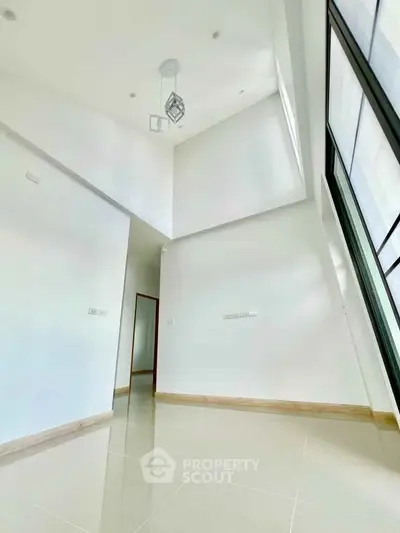 Spacious modern interior with high ceilings and large windows, perfect for natural light.