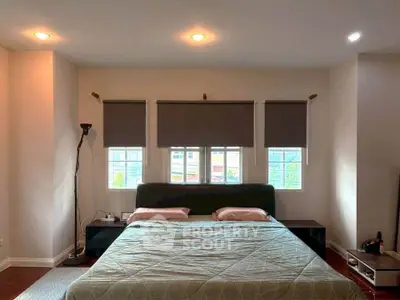 Spacious bedroom with large windows and modern decor, perfect for relaxation and comfort.