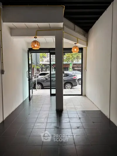 Spacious commercial space with large glass doors and modern lighting, ideal for retail or office use.