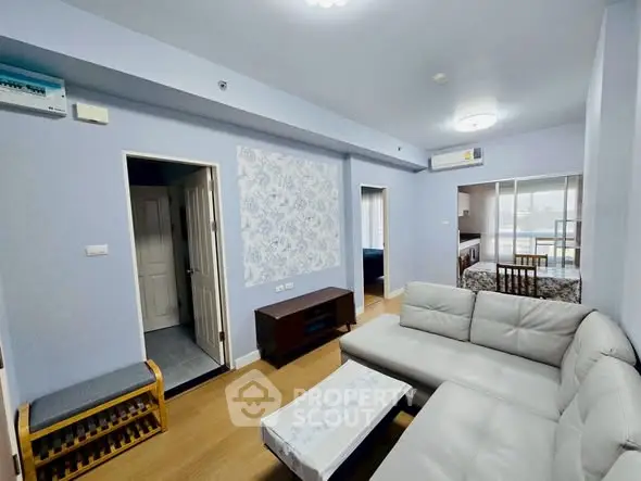 Spacious living room with modern decor and natural light in a stylish apartment.