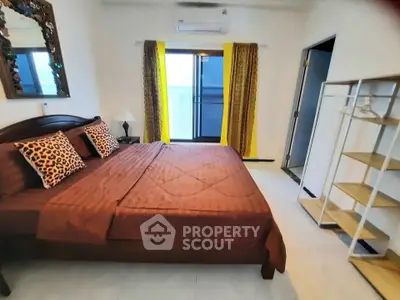 Spacious bedroom with stylish decor and balcony access in modern apartment.