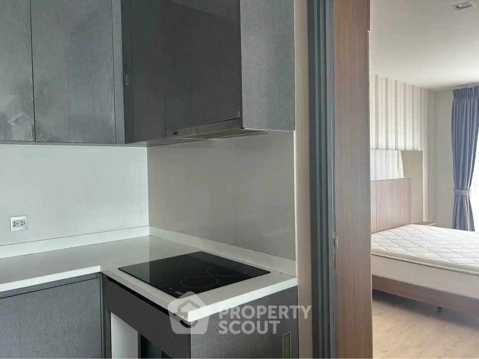 Modern kitchen with sleek design and adjacent bedroom view