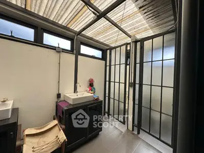 Modern bathroom with sleek design and ample natural light, featuring stylish fixtures and frosted glass partitions.