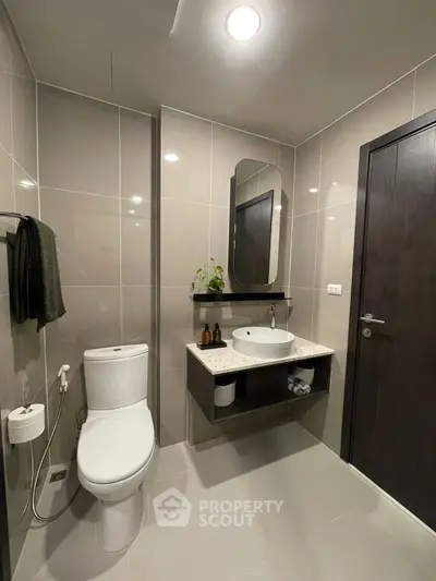 Modern bathroom with sleek fixtures and elegant design, featuring a wall-mounted sink and contemporary toilet.