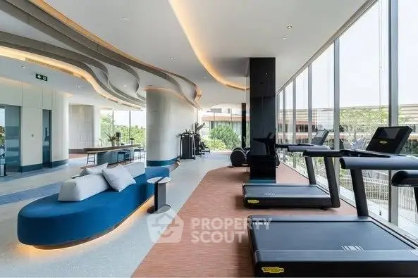 Luxurious gym with modern equipment and panoramic windows in upscale residential building.