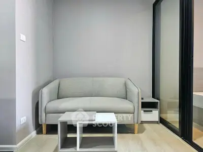 Modern living room with sleek gray sofa and minimalist coffee table in stylish apartment.