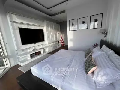 Luxurious bedroom with modern decor and large TV, perfect for relaxation and comfort.