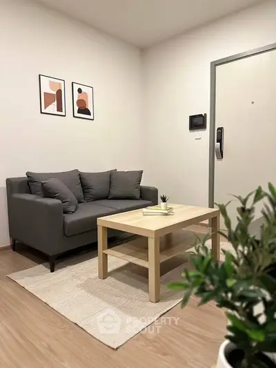 Modern living room with stylish gray sofa, wooden coffee table, and minimalist decor.