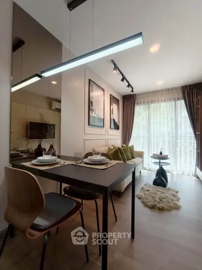 Modern living room with dining area, stylish decor, and large window for natural light.