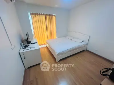 Cozy minimalist bedroom with wooden flooring and natural light